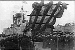 18.jpg: Митинг на крейсере «Киров» в годы блокады. Обратите внимание на маскировку кормовой башни корабля и временную грот-мачту, установленную взамен разрушенной взрывом бомбы.